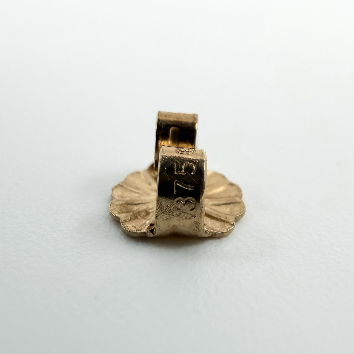 Close up of a 9ct gold butterfly back stamped 375 for the cultured black pearl stud earrings