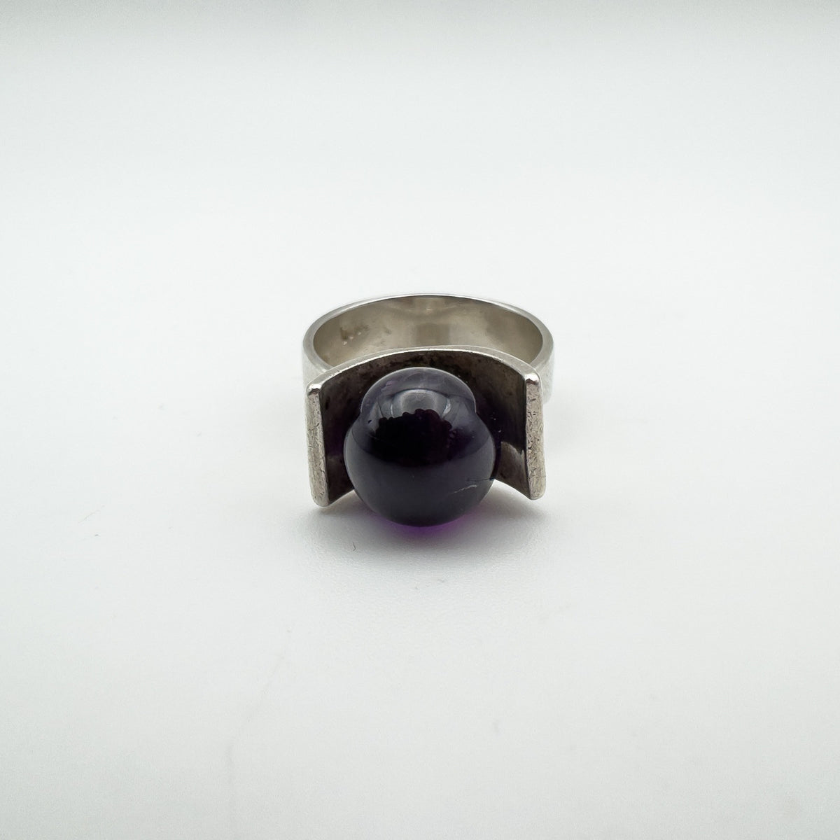 Bold amethyst ball nestled in modernist sterling silver ring, full front angle