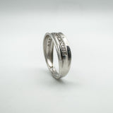 Upright angled view of sterling silver diamond band showing flush setting and 925 stamp
