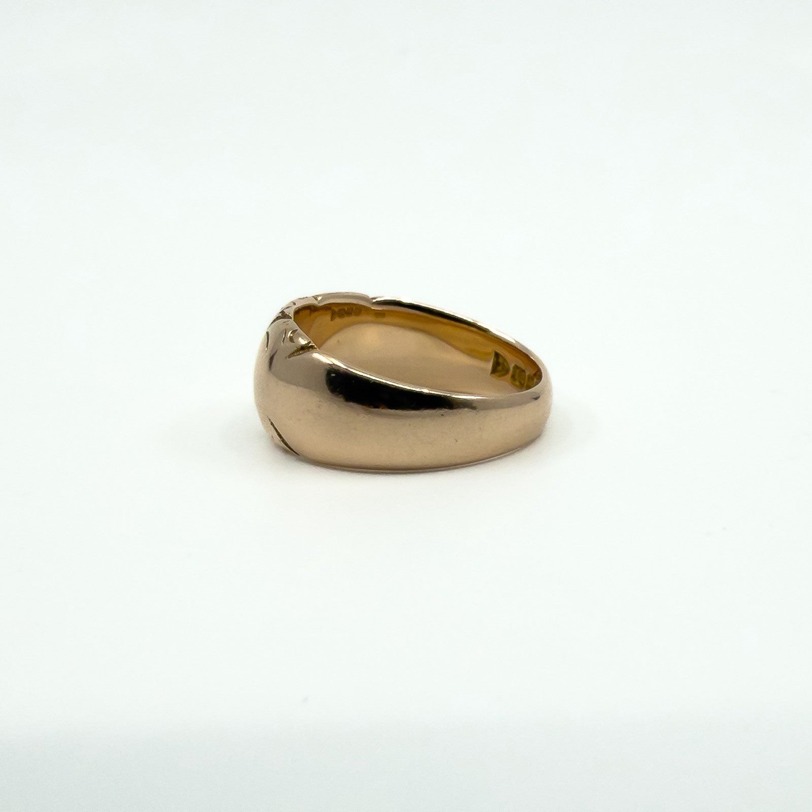 Side angle of antique 12ct rose gold band ring showing engraving and rounded top