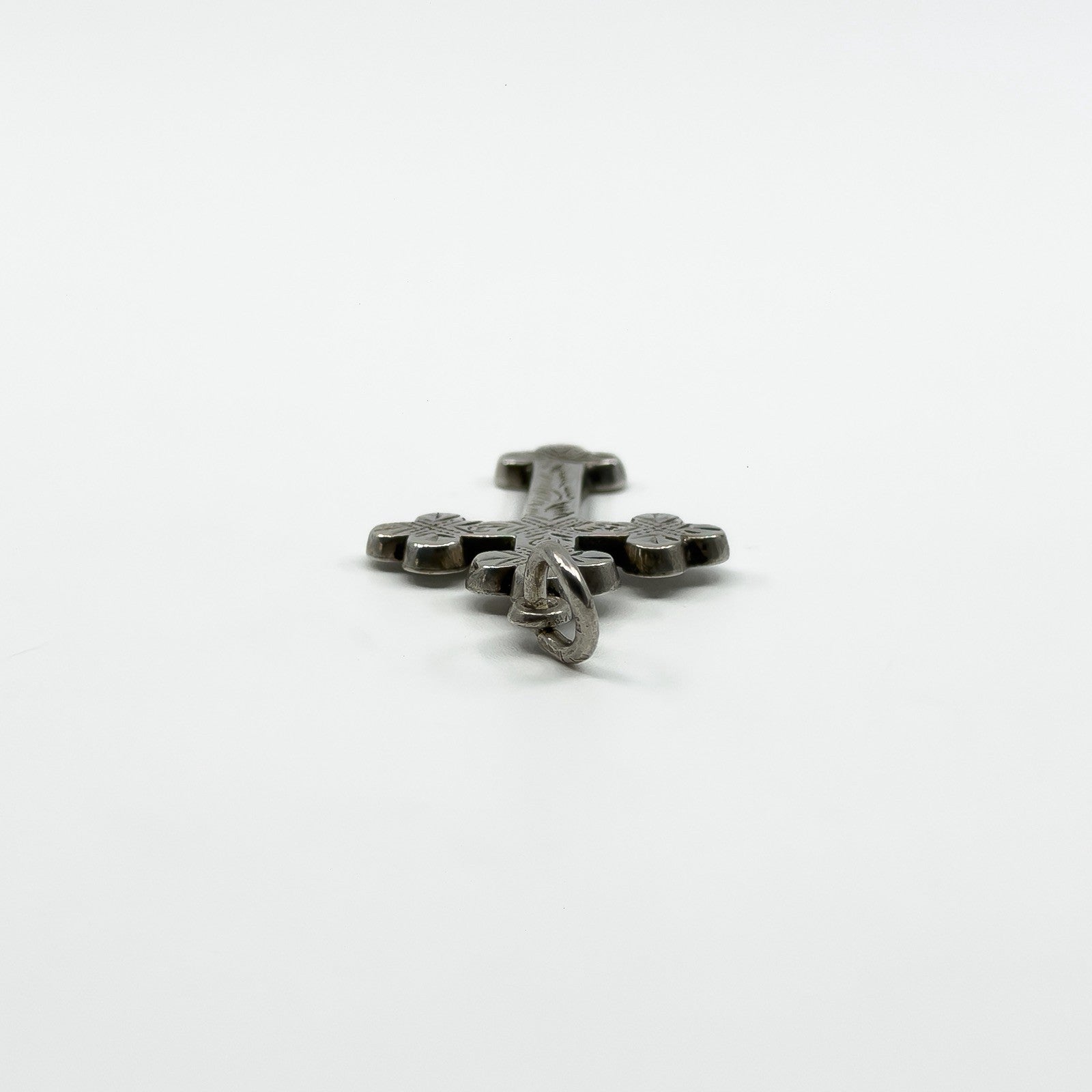 Close view of the large bail on the antique engraved silver cross pendant from the end
