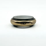 Low side view of antique rolled gold glass photo locket showing its rounded frame and domed glass
