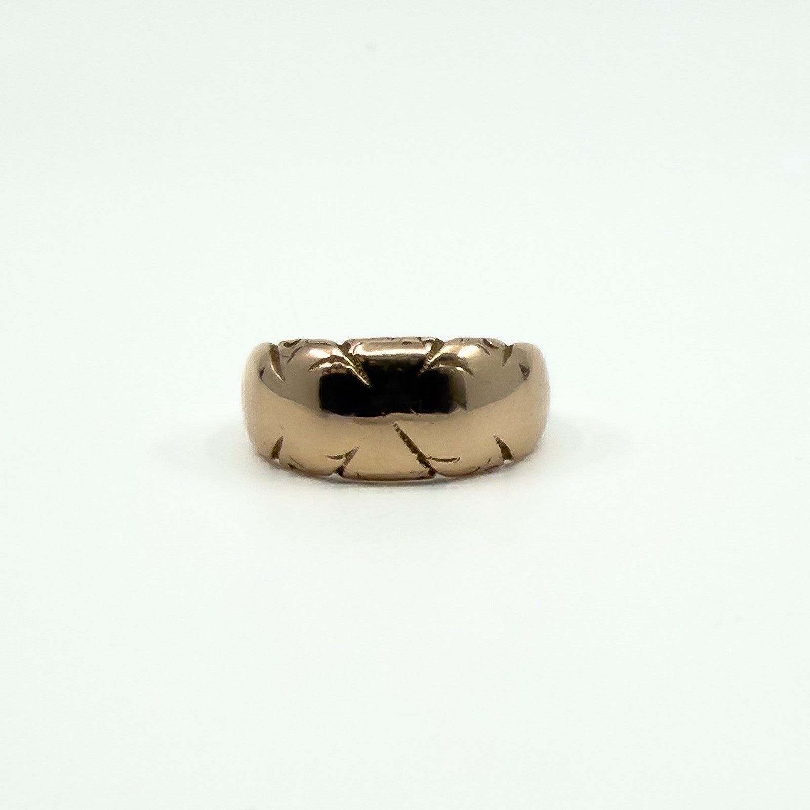 Straight-on view of antique 12ct rose gold wide band ring Size J, showing domed band and engraving