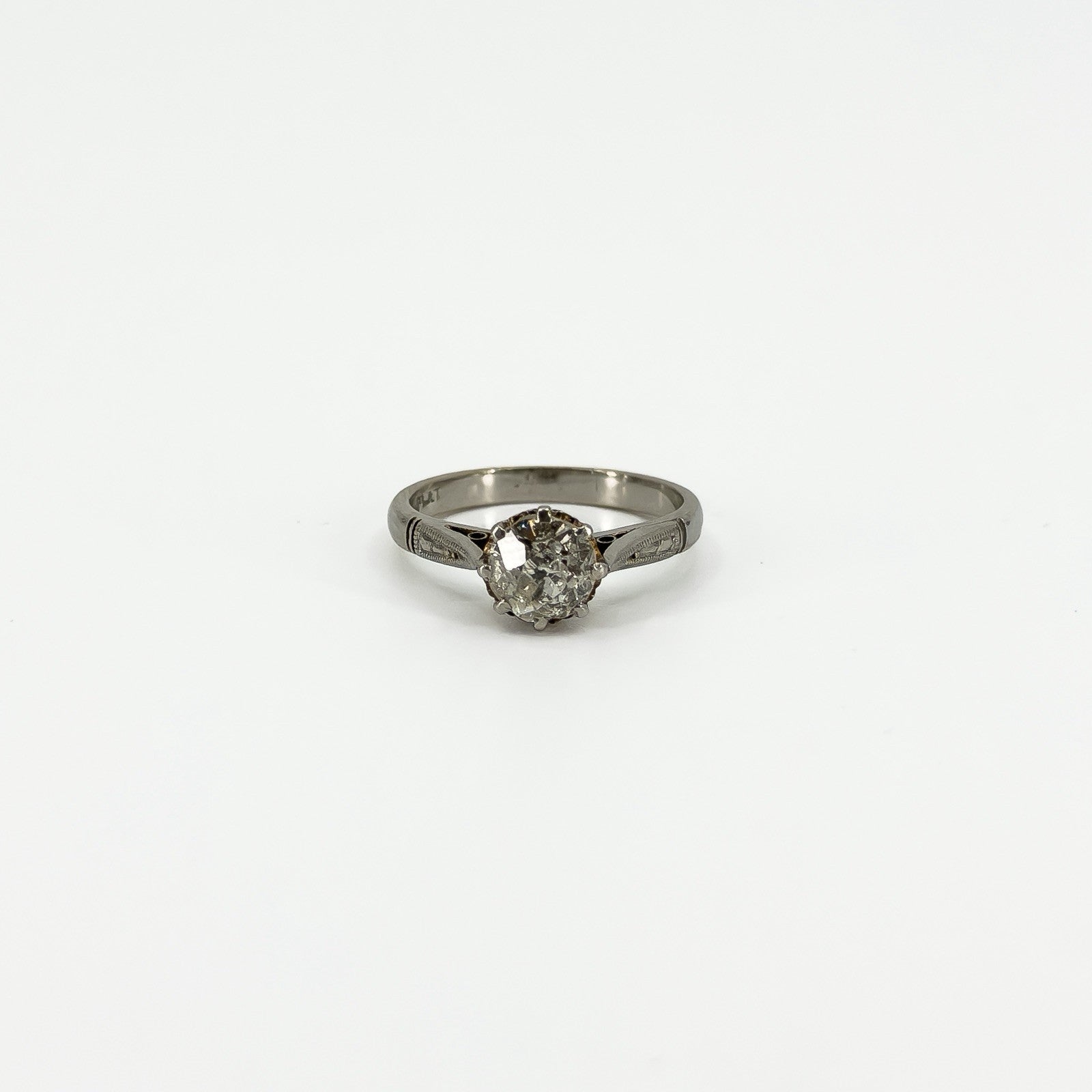 Front view of antique platinum old-cut diamond solitaire ring with engraved shoulders