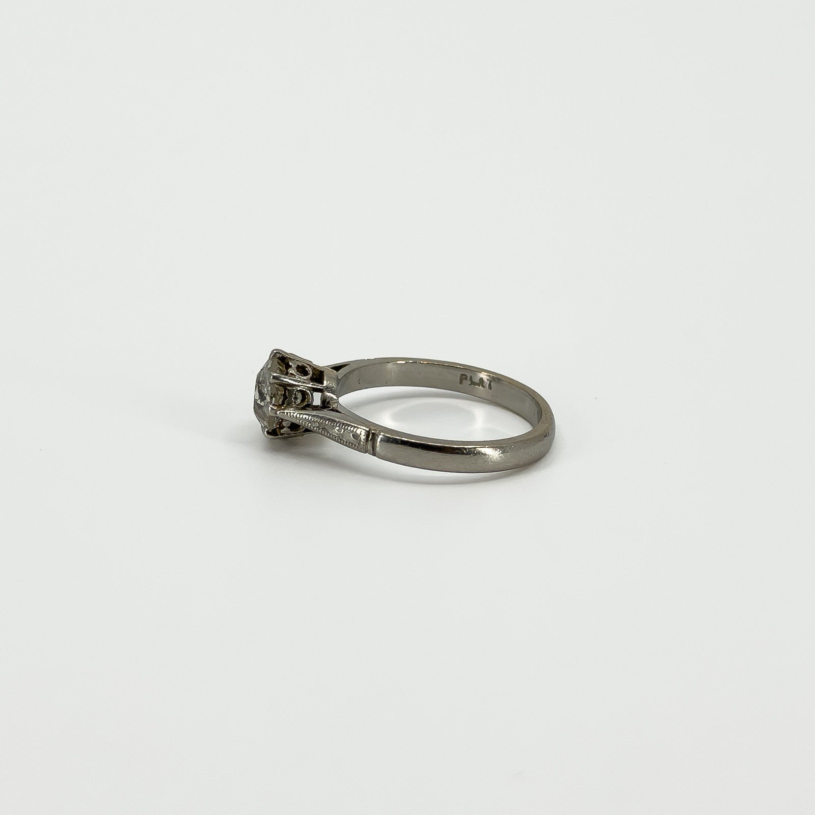 Side profile of antique old-cut diamond solitaire ring with PLAT mark visible inside the band