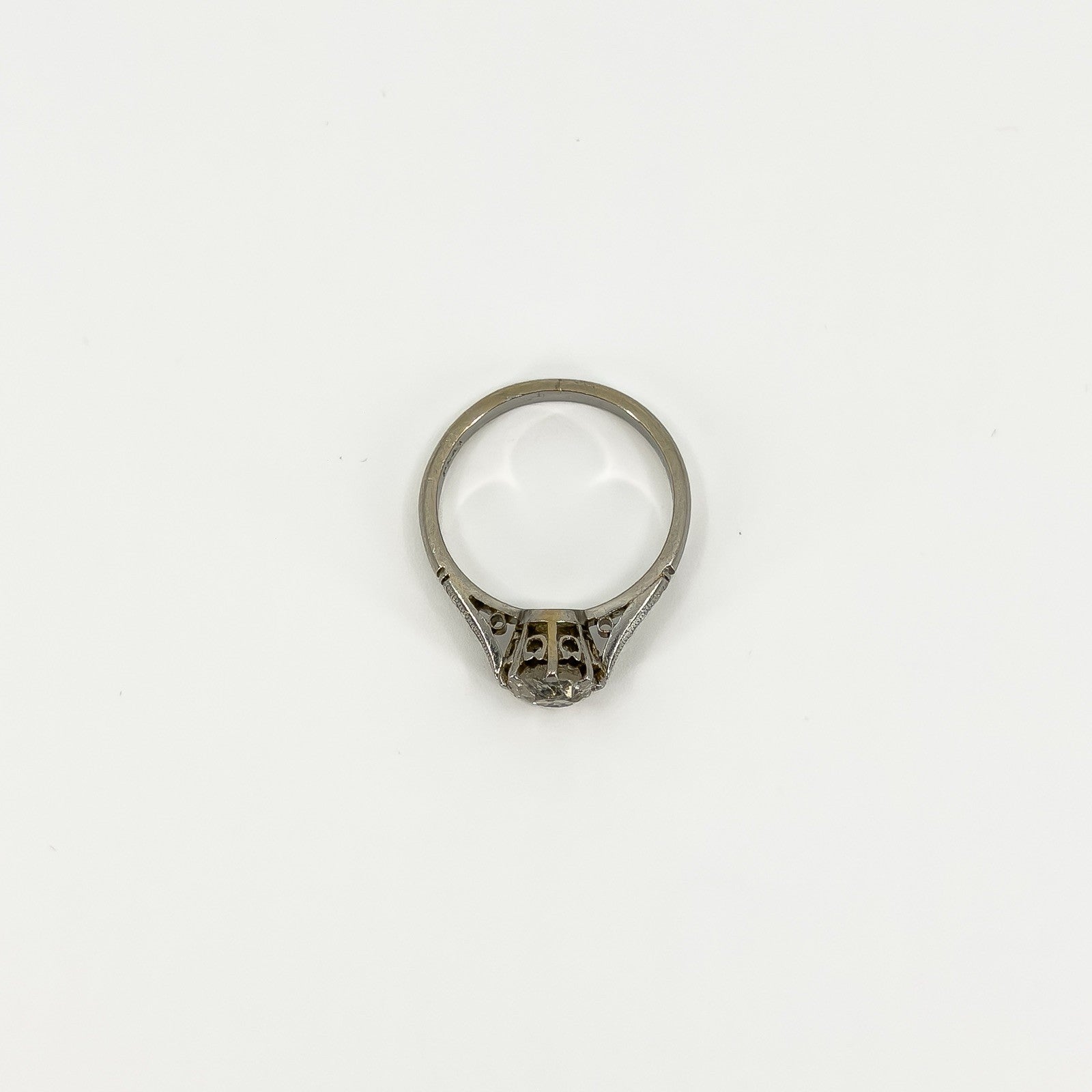 Top view of antique platinum diamond solitaire ring showing open gallery and engraved shoulders