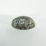 Close front view of Art Deco platinum diamond trilogy ring with filigree openwork