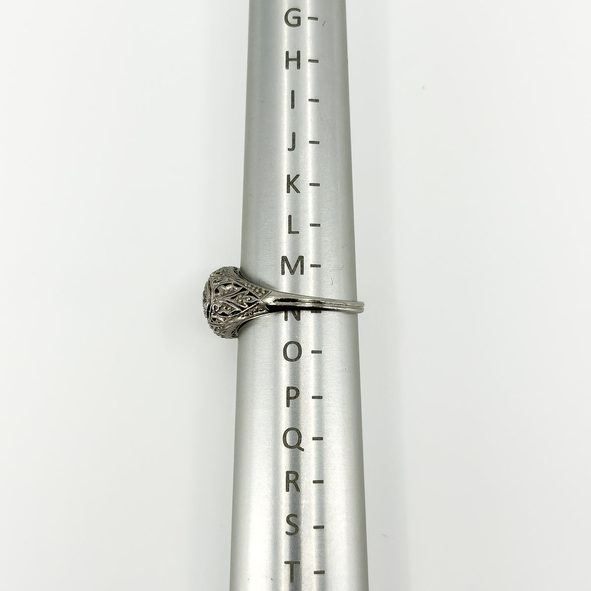 Side view of Art Deco platinum diamond ring on a metal ring sizing mandrel