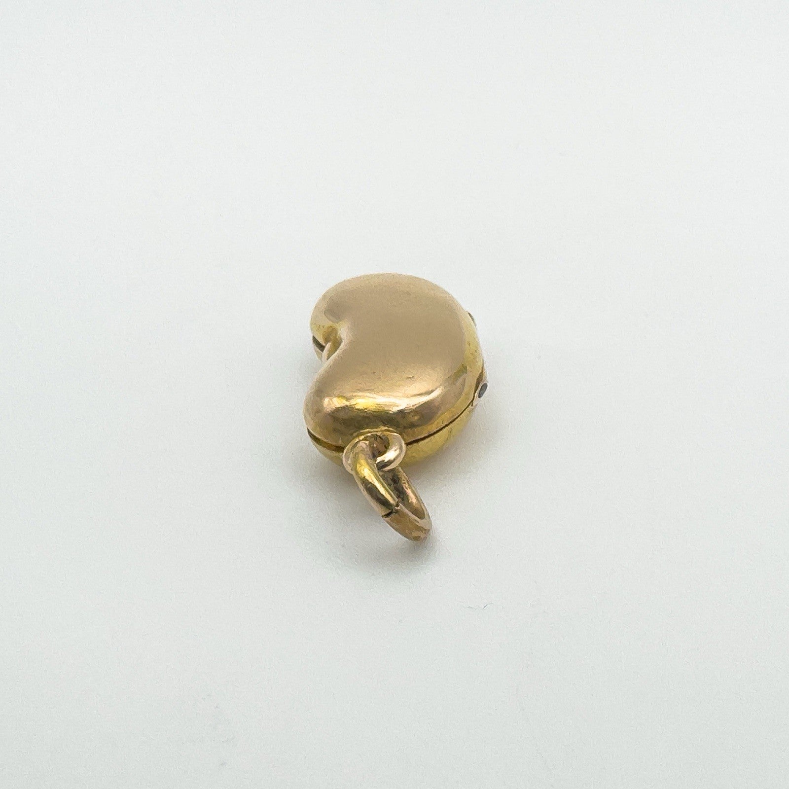 Tactile kidney bean locket in 18ct gold viewed from the reverse with top loop