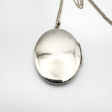 Plain back of vintage oval silver locket pendant on chain