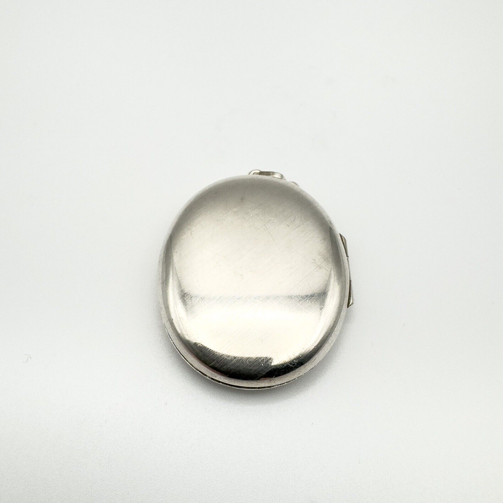 Close-up of plain reverse side of chunky oval sterling silver locket