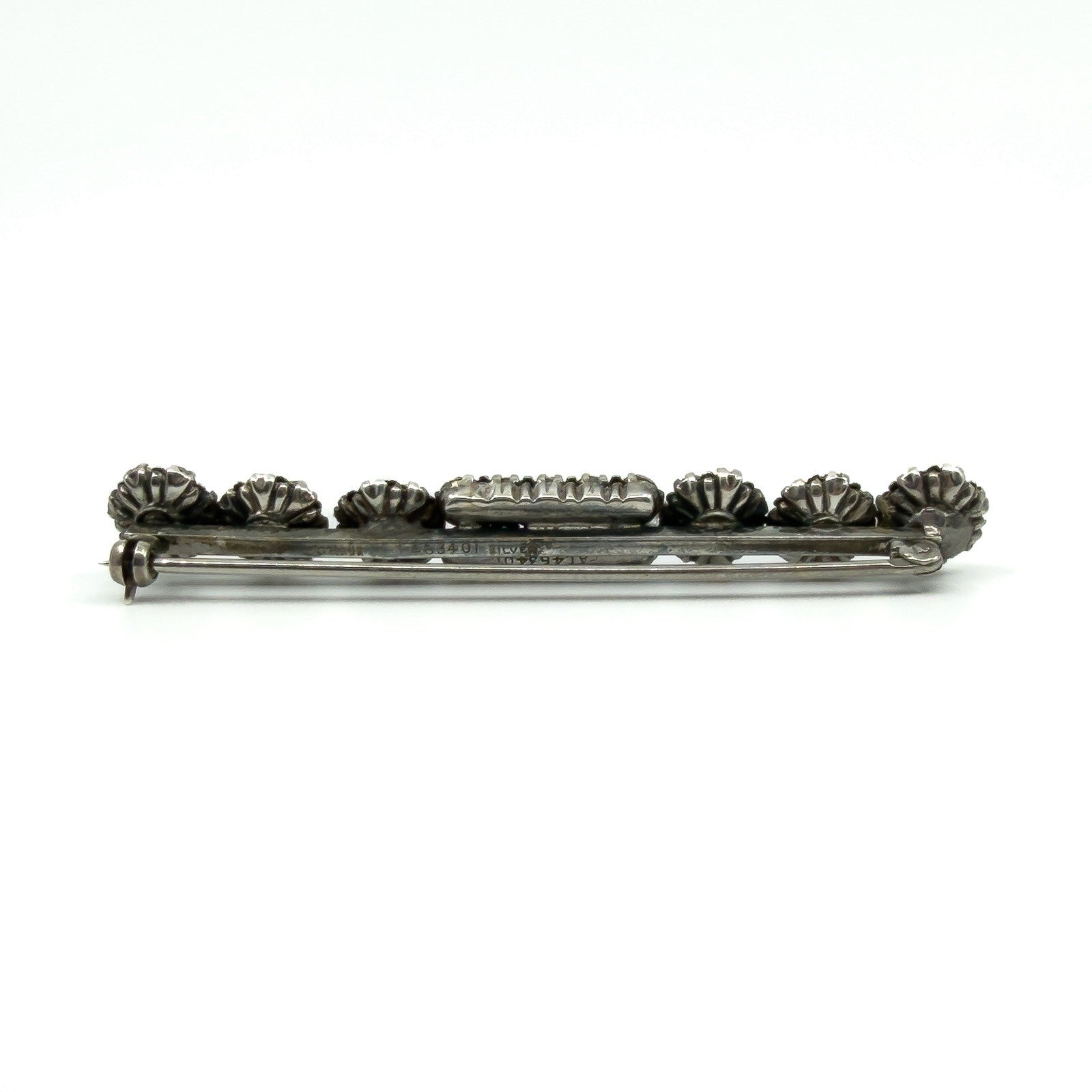 Back of sterling silver paste and pearl bar brooch showing pin and rolling C clasp fitting.