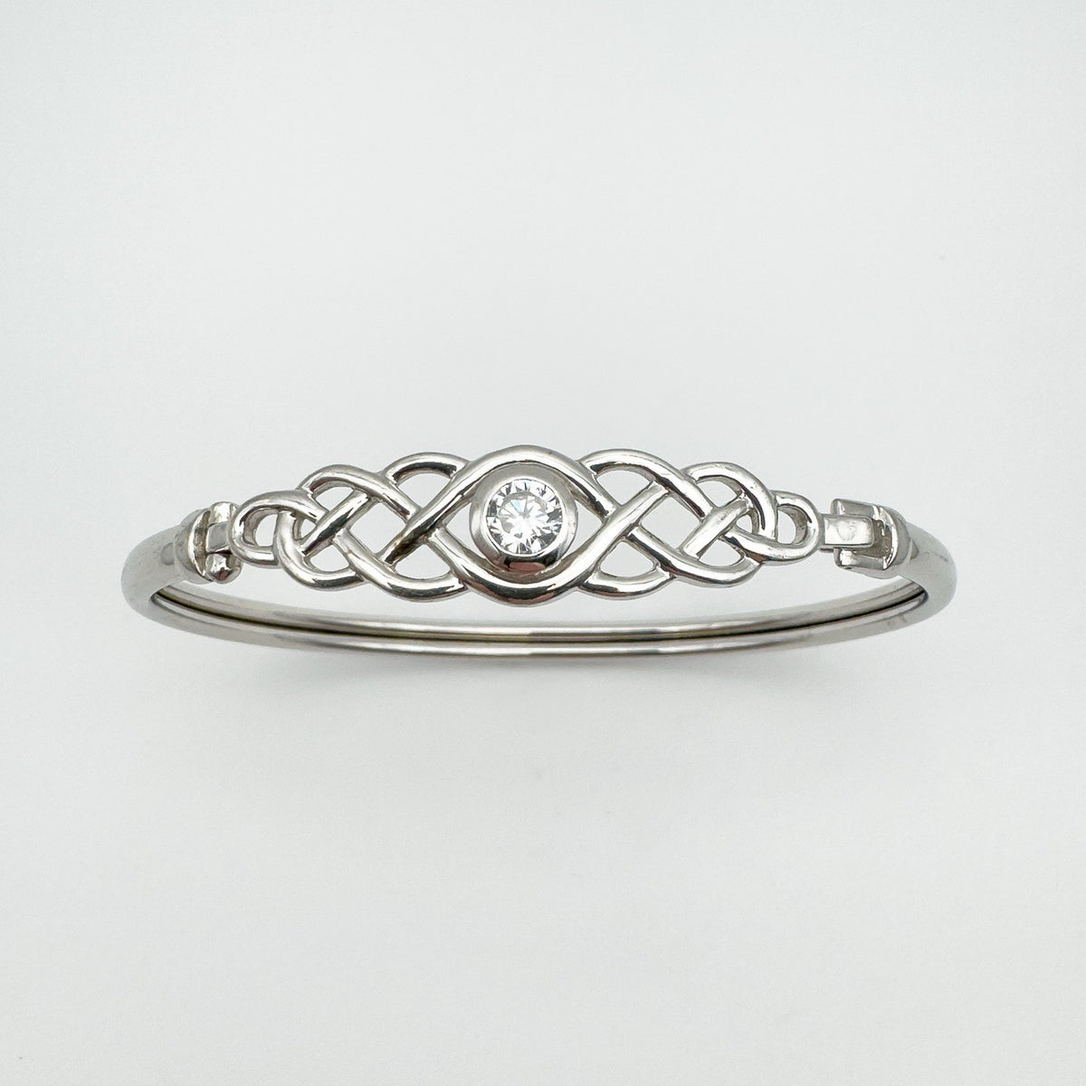 Well-lit front-facing view of Celtic bangle with centred cubic zirconia
