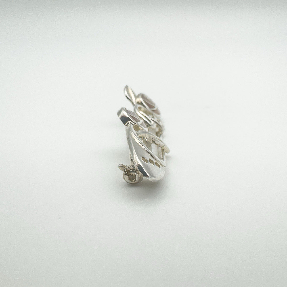 Angled detail showing side profile of sterling silver and shell Celtic brooch
