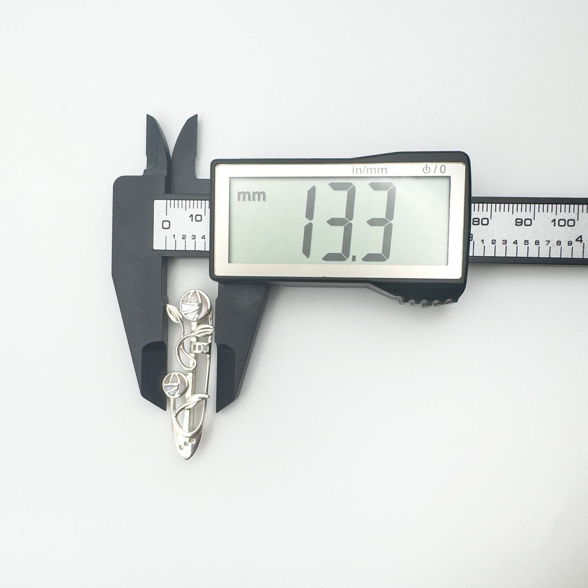 Measuring height of vintage mother of pearl Celtic brooch at 13.3mm