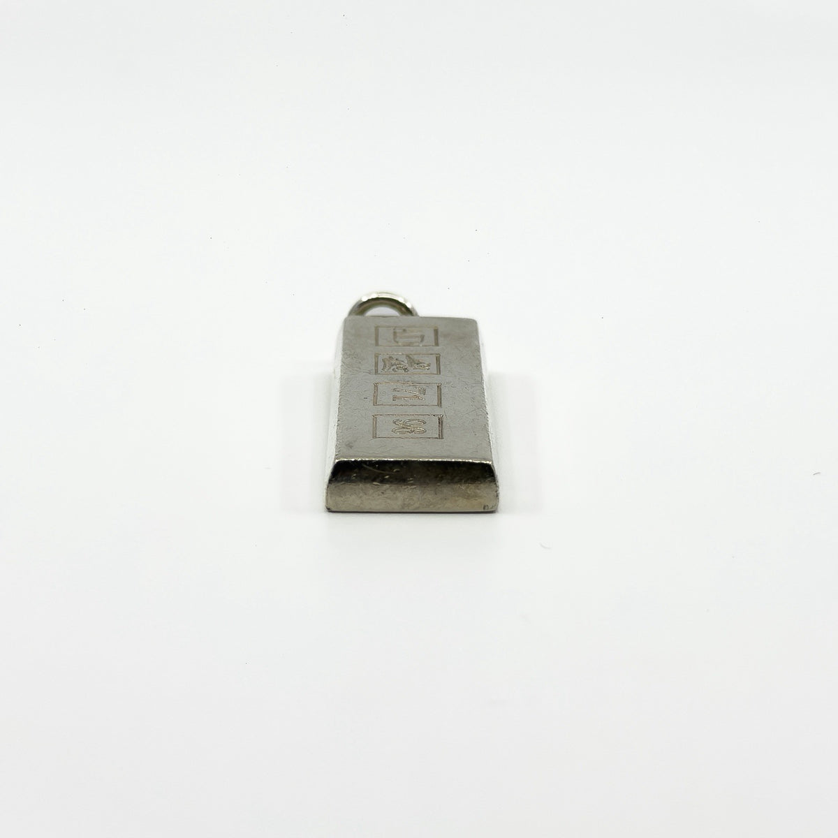 End view of the chunky sterling silver ingot pendant showing the bail and solid rectangular form.