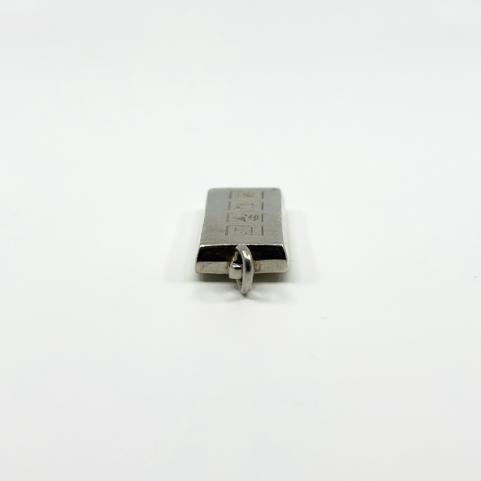 Side view of the chunky sterling silver ingot pendant showing the bail and rectangular depth.