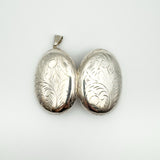 Both sides of silver oval locket with scrollwork design