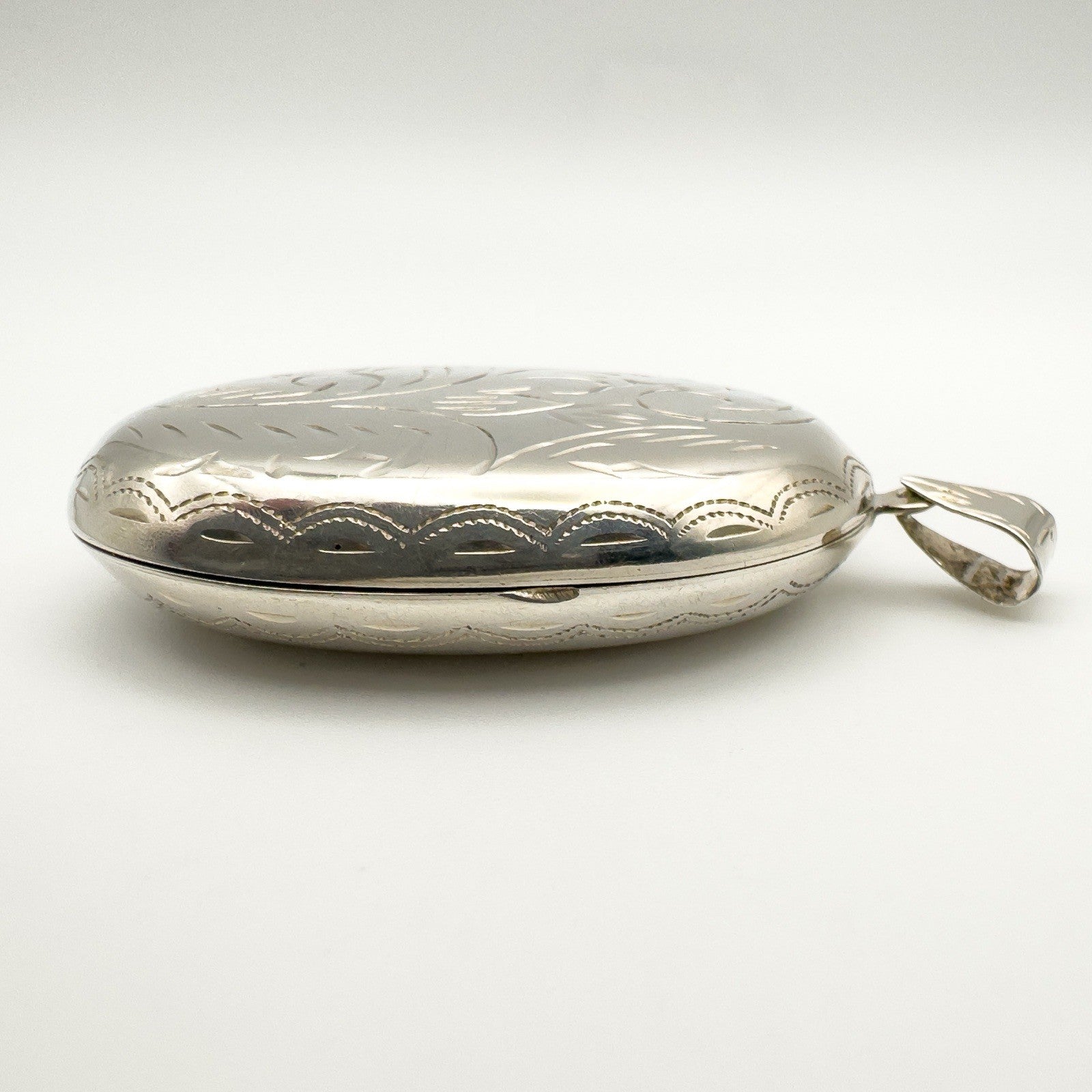 Side view showing engraved edge of oval locket