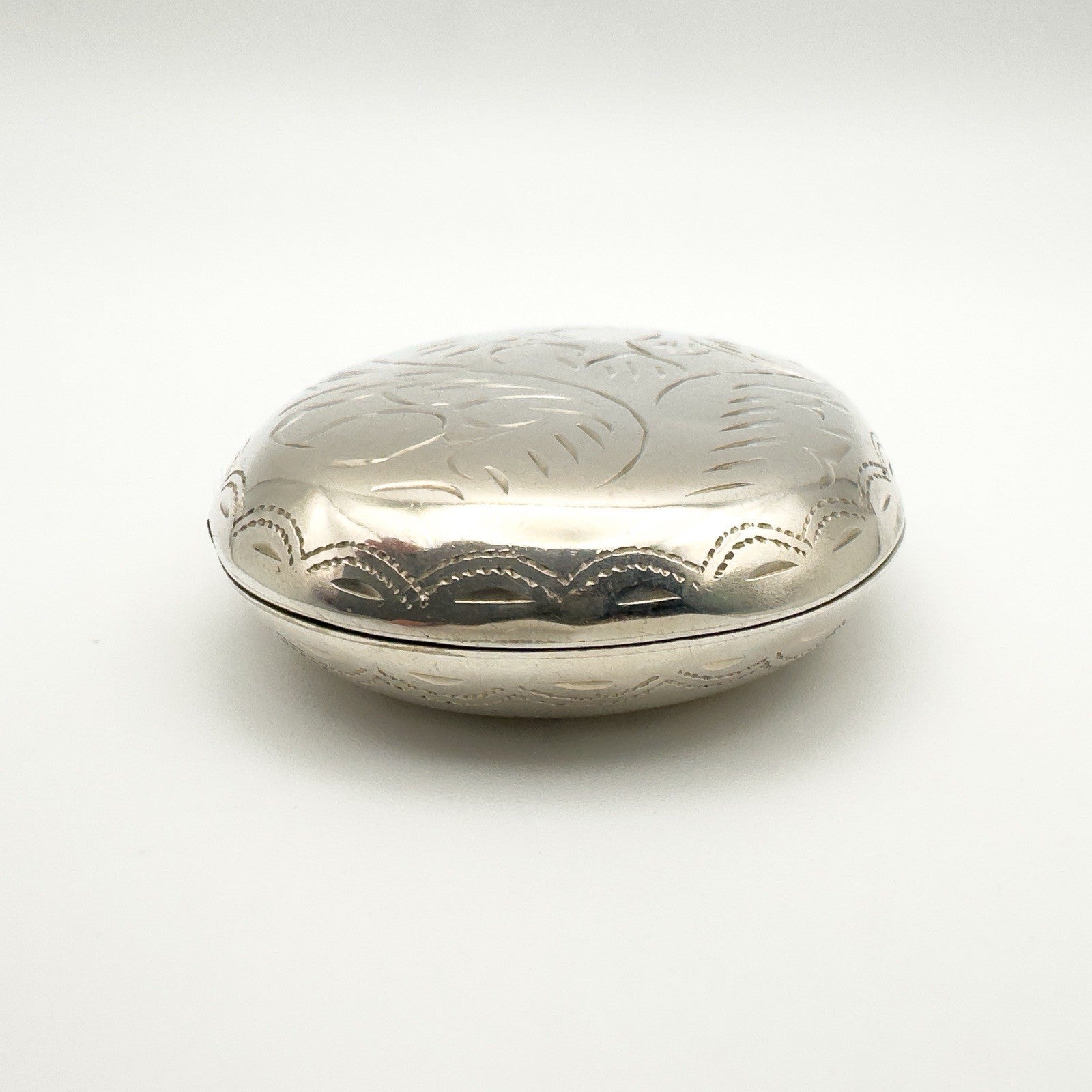 Front facing view of large engraved silver locket