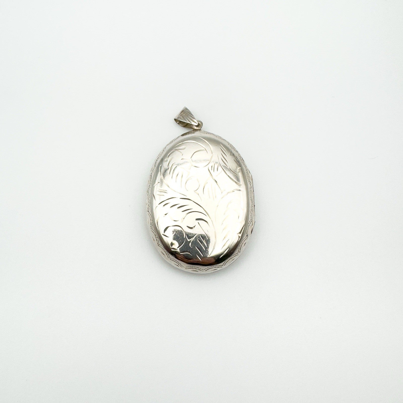 Front facing view of large engraved silver locket