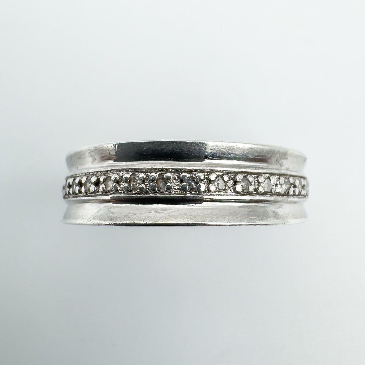 Close-up of 14 round cut diamonds set in a sterling silver half hoop band