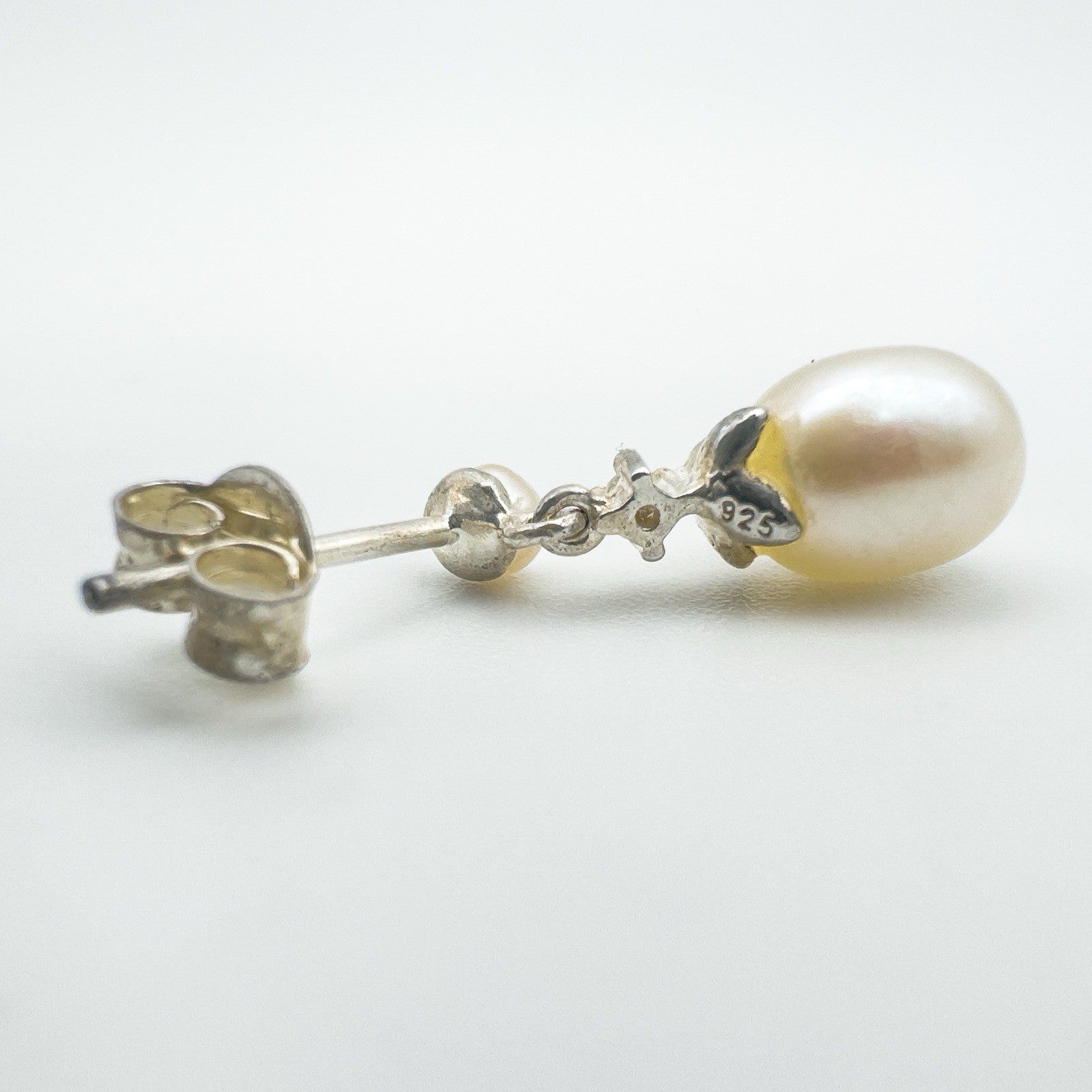 Close-up of 925 stamp and setting on pearl and CZ earring