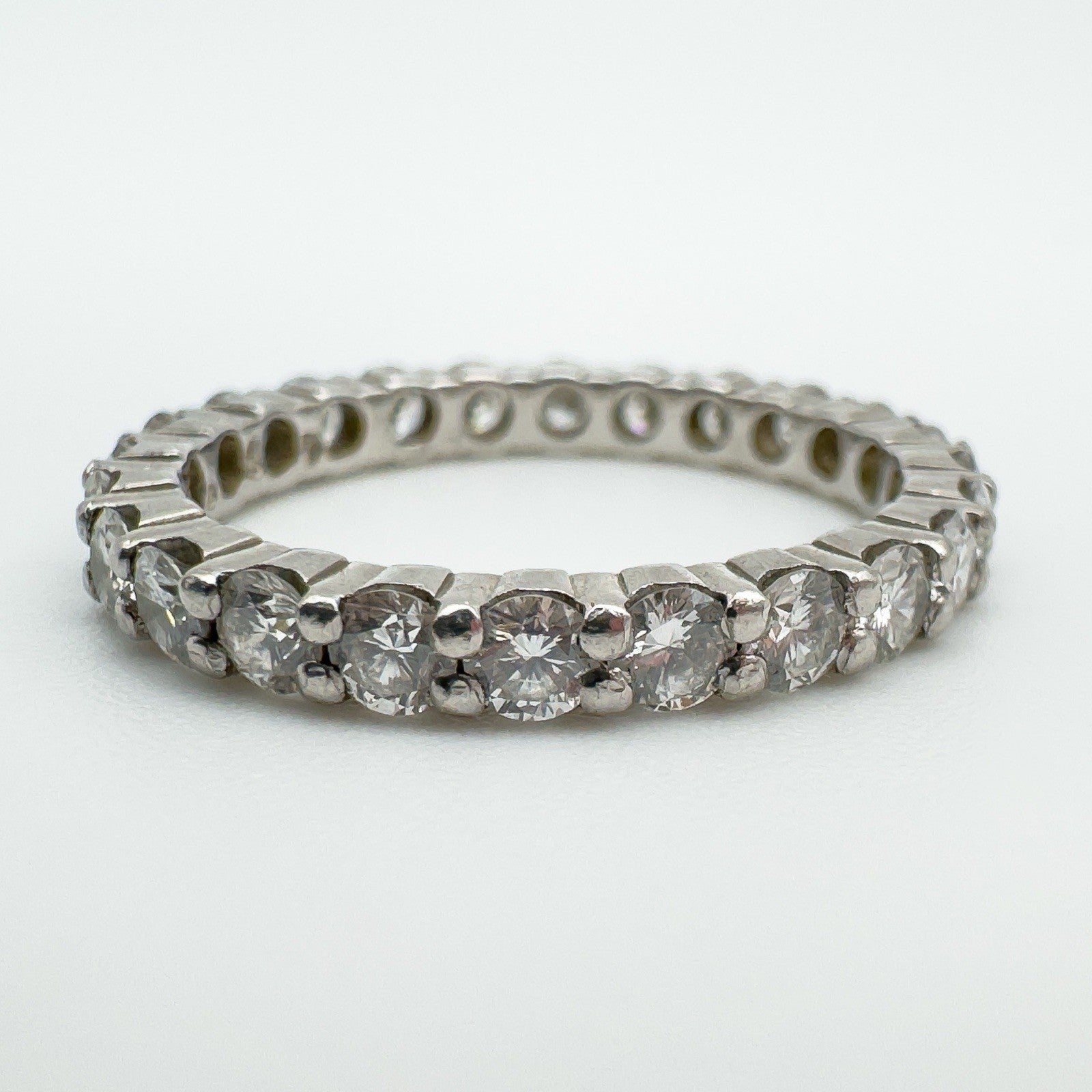 Close-up of prong-set round diamonds in platinum eternity band