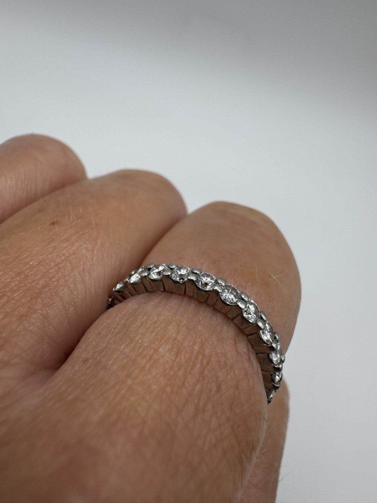 Close-up of platinum diamond eternity ring showing prong setting and sparkle