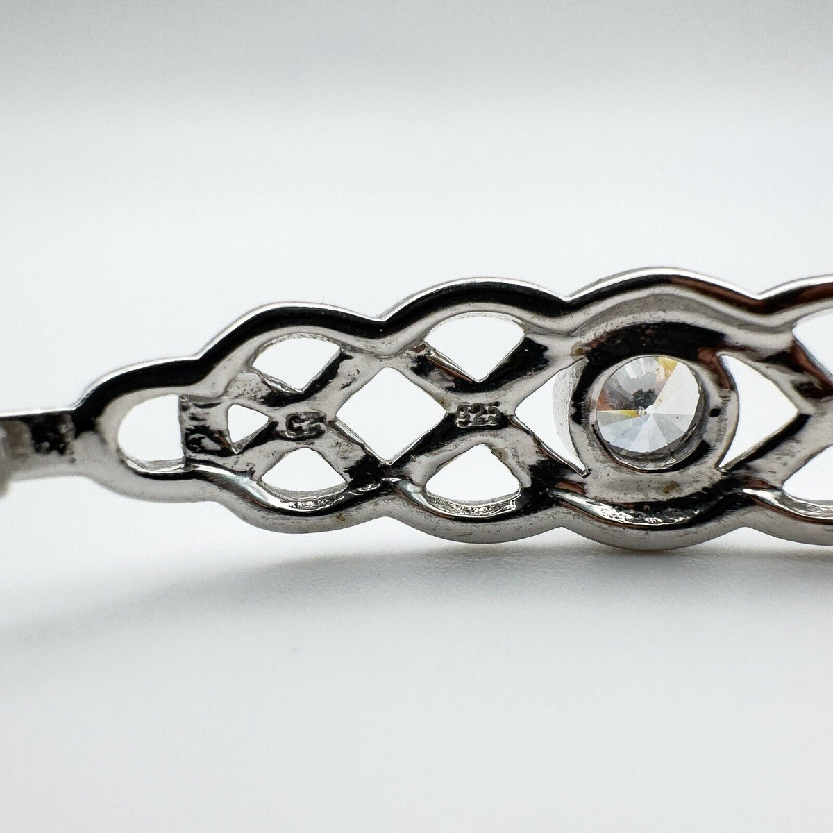 Detailed shot of 925 and CZ stamp markings behind the open Celtic knotwork