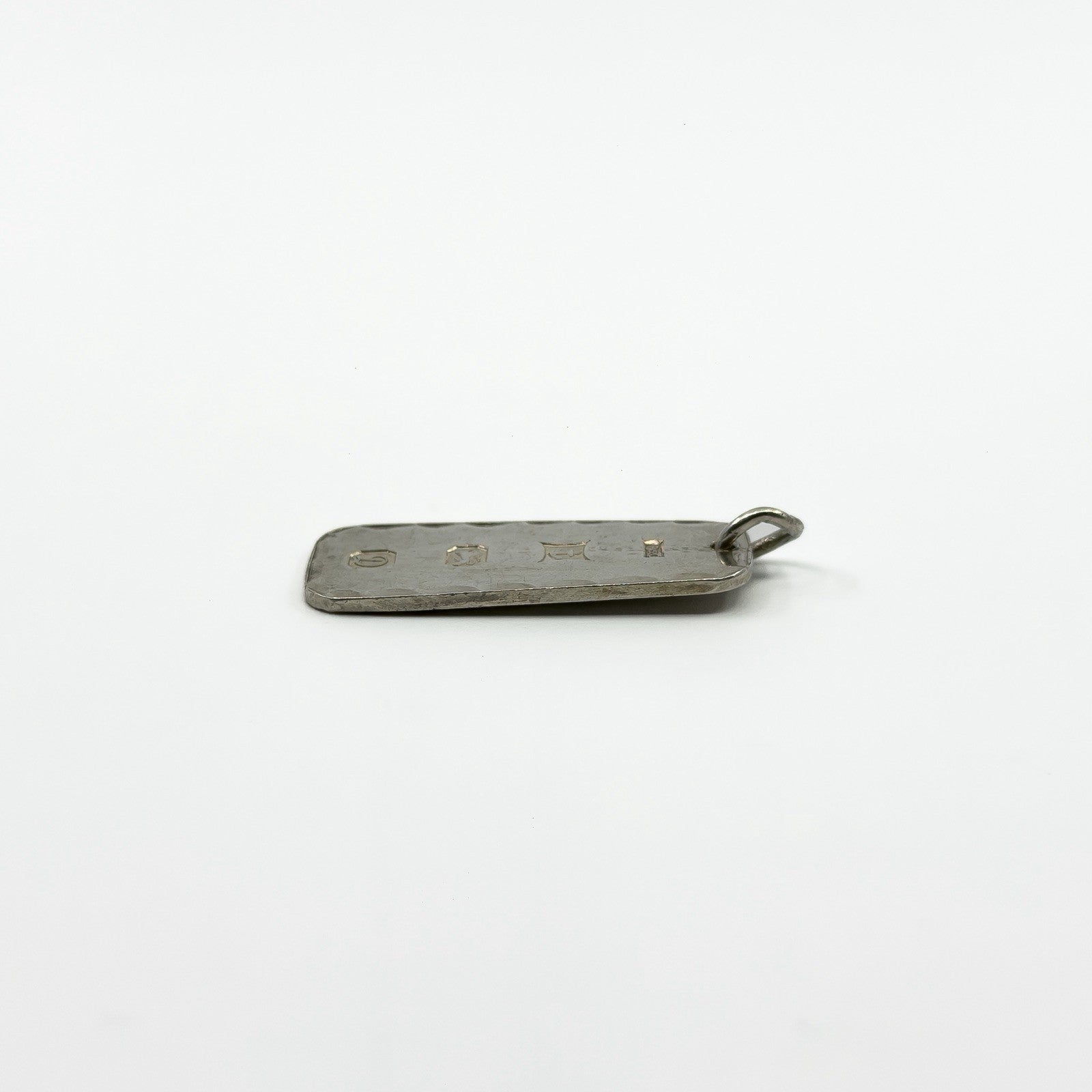 Close view of vintage sterling silver ingot pendant showing P&G Birmingham 1978 hallmarks.