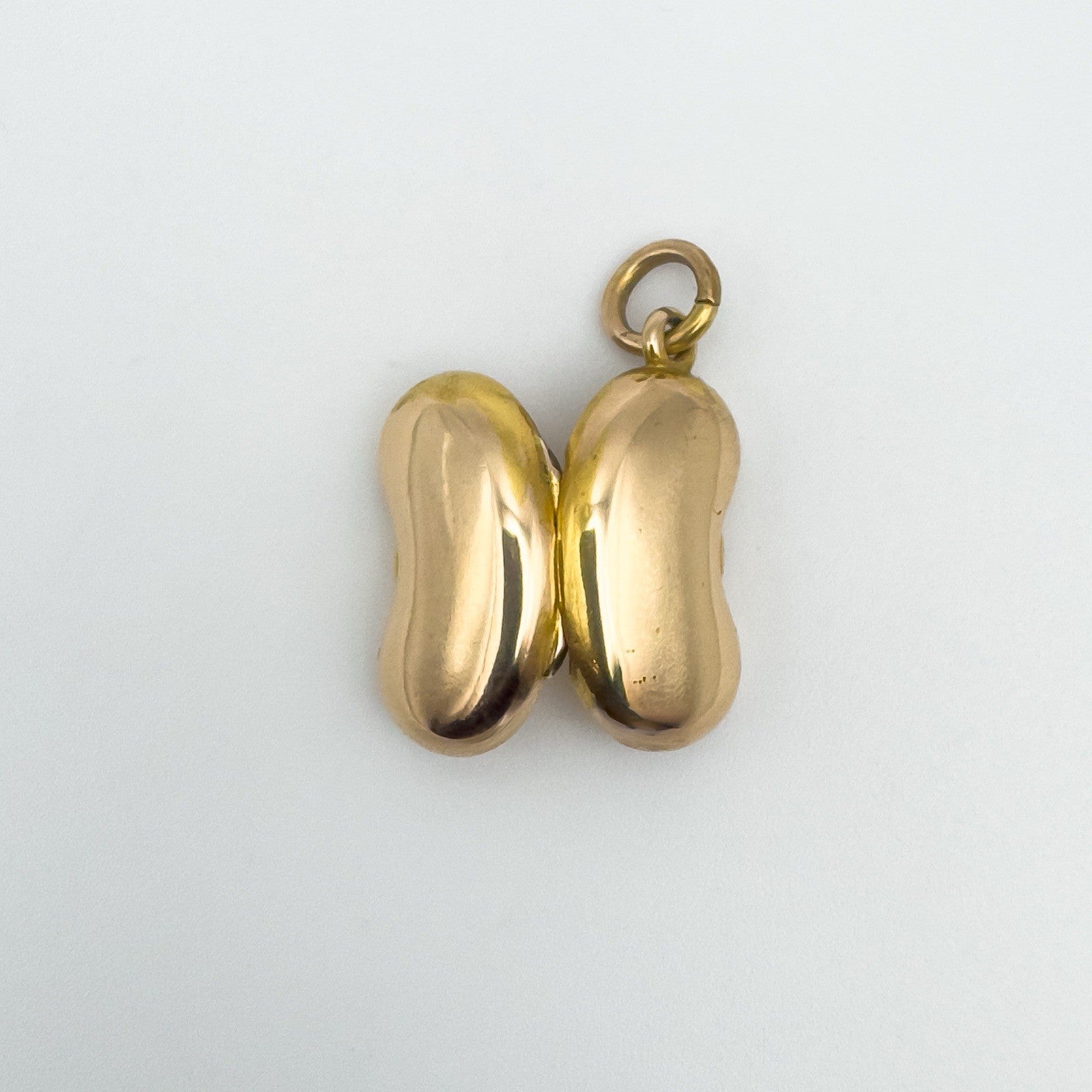 Vintage kidney bean locket in 18ct gold shown closed with both halves aligned