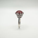 Detailed silver crown setting holding 8.5ct round carnelian stone