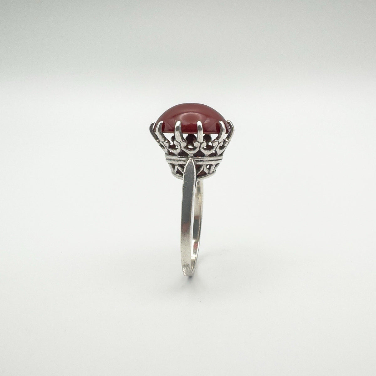 Detailed silver crown setting holding 8.5ct round carnelian stone