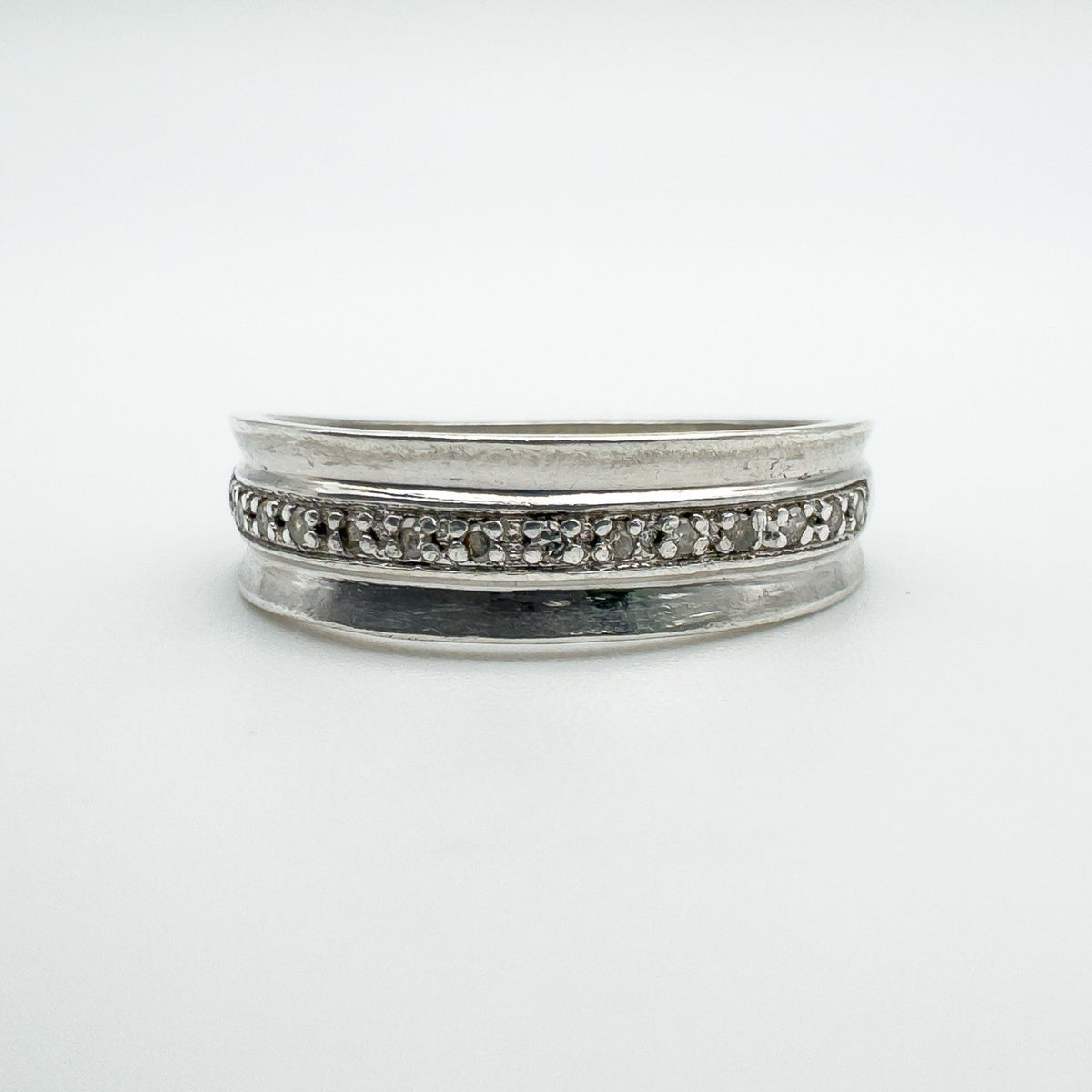 Front view of sterling silver diamond half hoop ring with flush claw setting