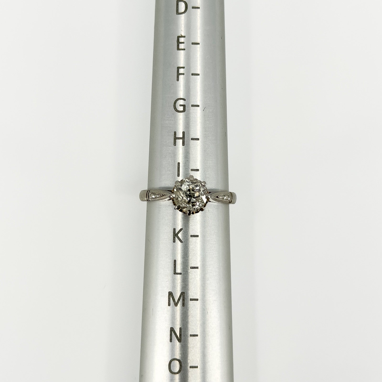 Antique platinum old-cut diamond solitaire ring shown on a ring size mandrel