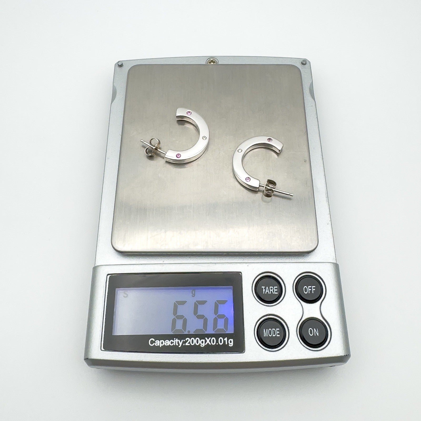 Pair of sterling silver earrings with pink sapphires and diamond weighing 6.56g on digital scale