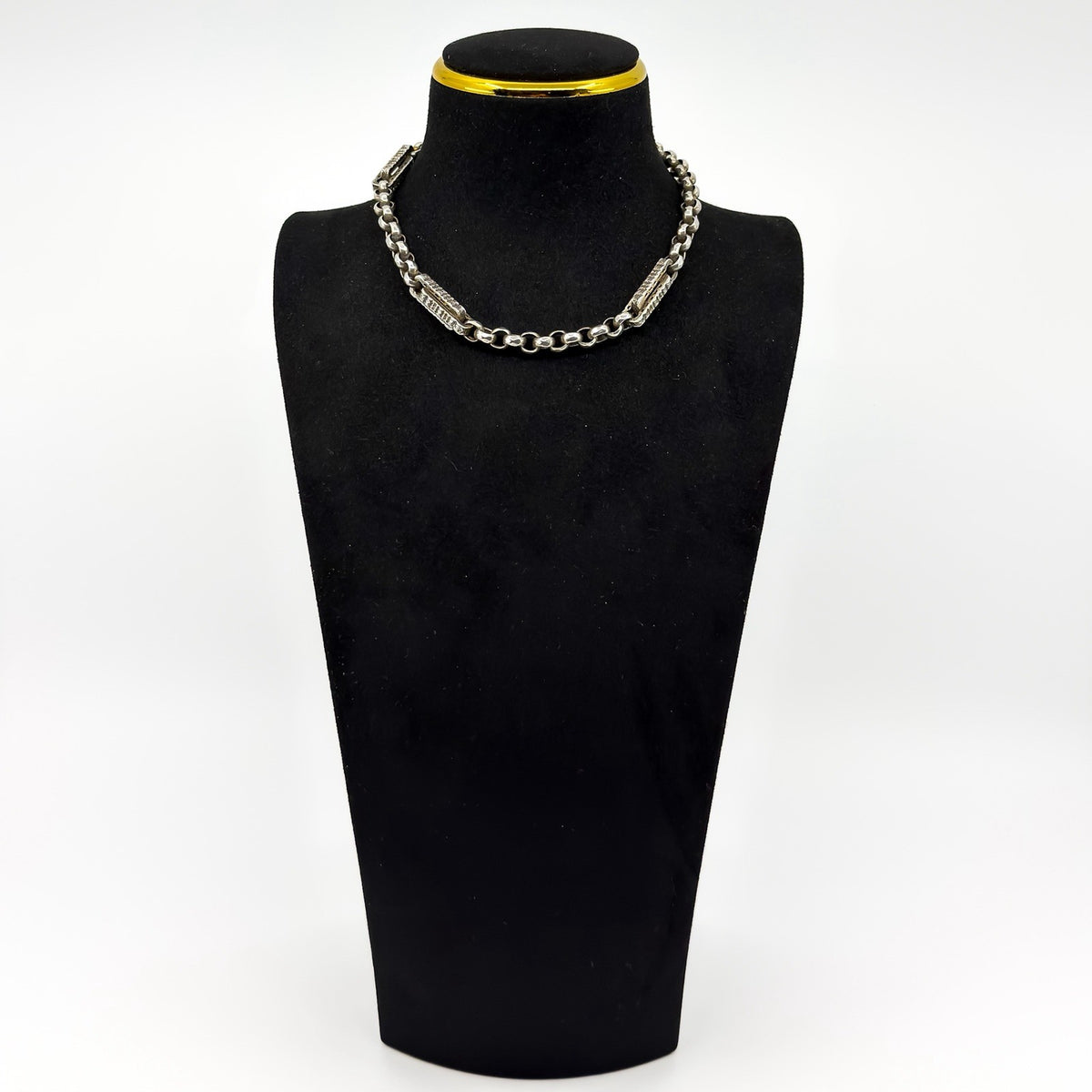 Antique sterling silver Albert chain shown on display bust with engraved bars and faceted round links