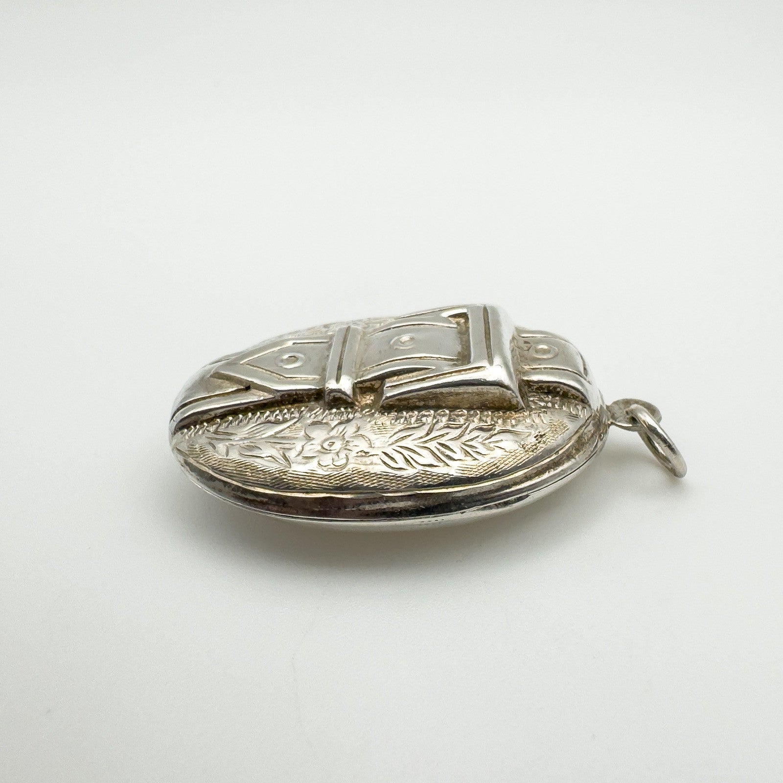 Side view showing floral engraving on sterling silver locket