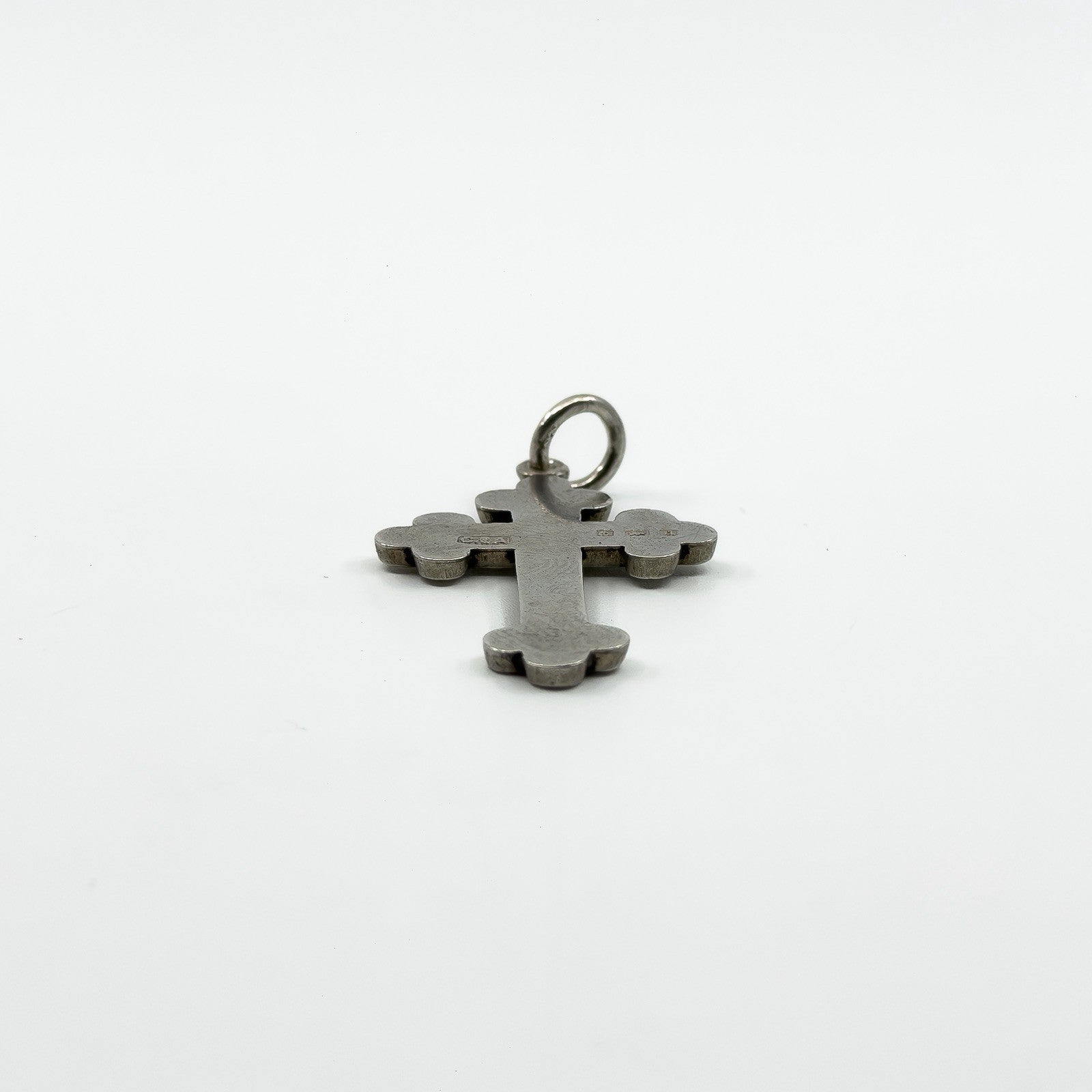 Low side angle of engraved antique sterling silver cross pendant with rounded trefoil ends