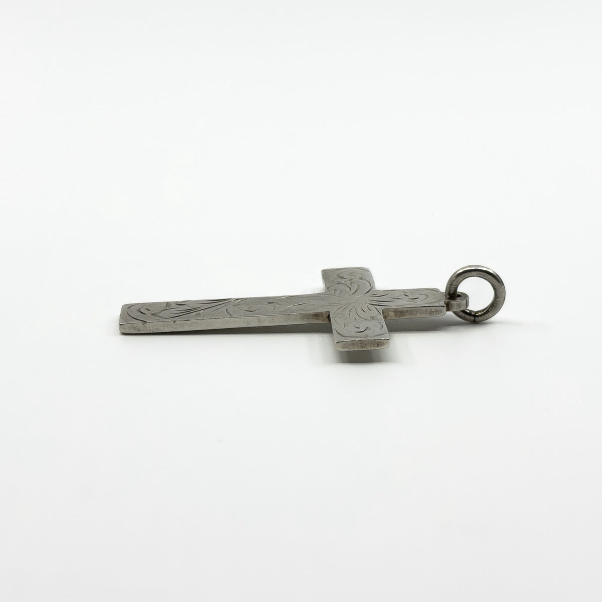 Side view of the vintage sterling silver engraved cross pendant showing the slim profile.