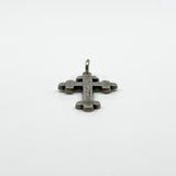 Low side view of antique Victorian silver cross pendant showing engraved face and depth