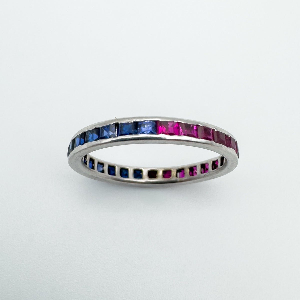 Channel set sapphire and ruby full eternity band in white gold, flat angle