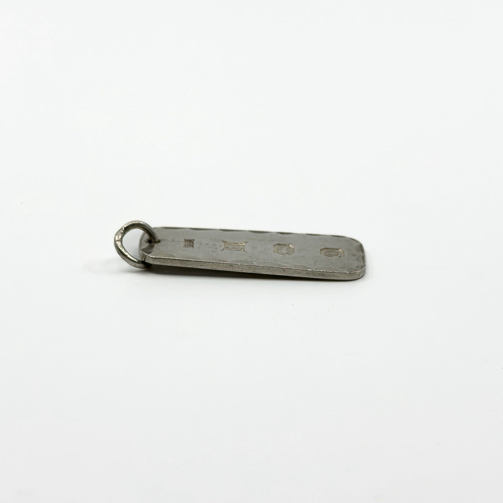 Vintage sterling silver ingot pendant lying flat with full hallmarks visible on the reverse.