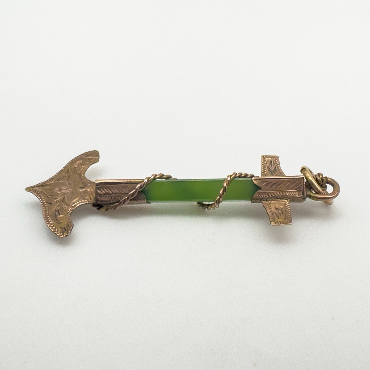 Antique nautical pendant laid flat to show gold and jade bar detail