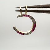 Front view of ruby and diamond horseshoe charm held up for detail