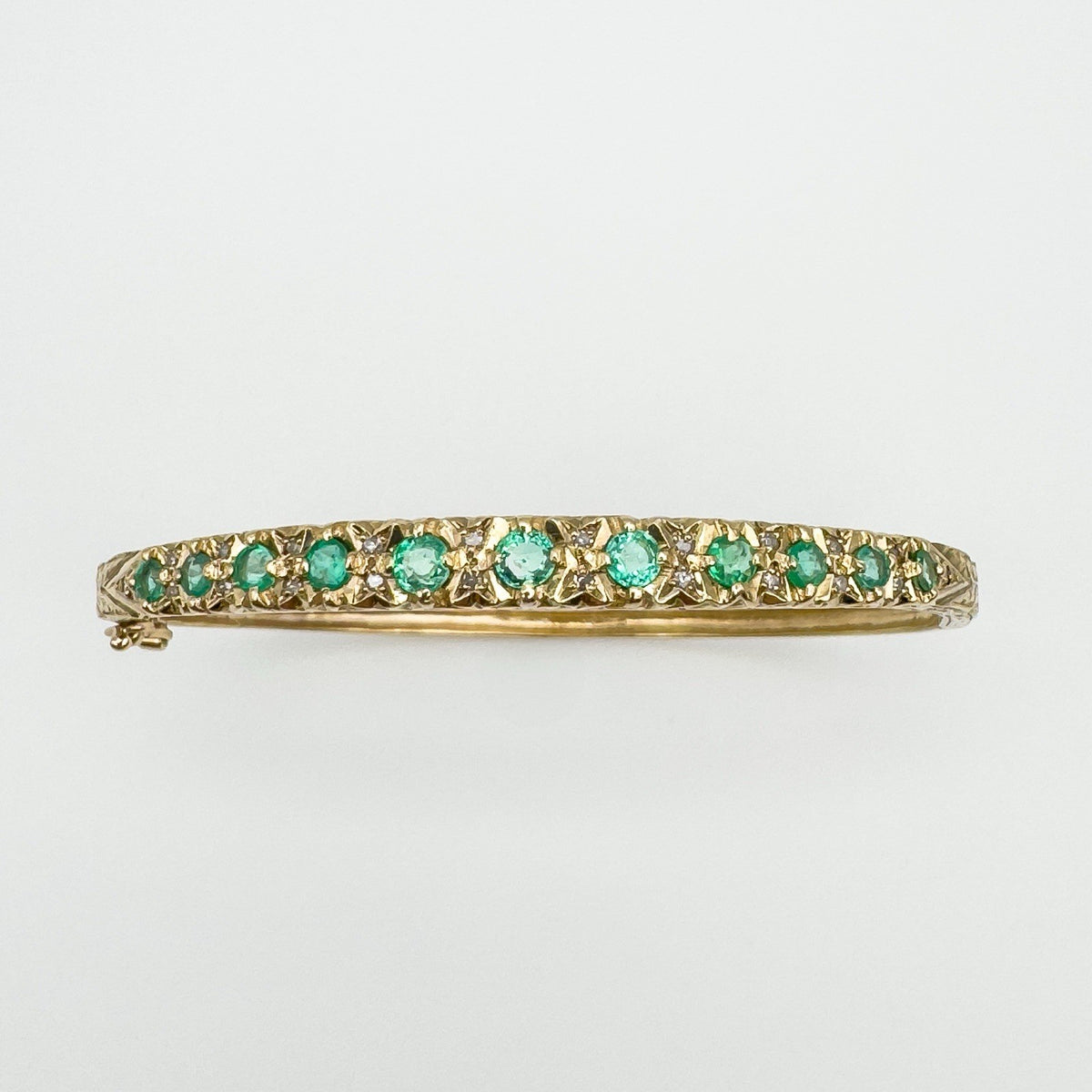 Full view of vintage gold bangle with 11 emeralds and 22 diamonds