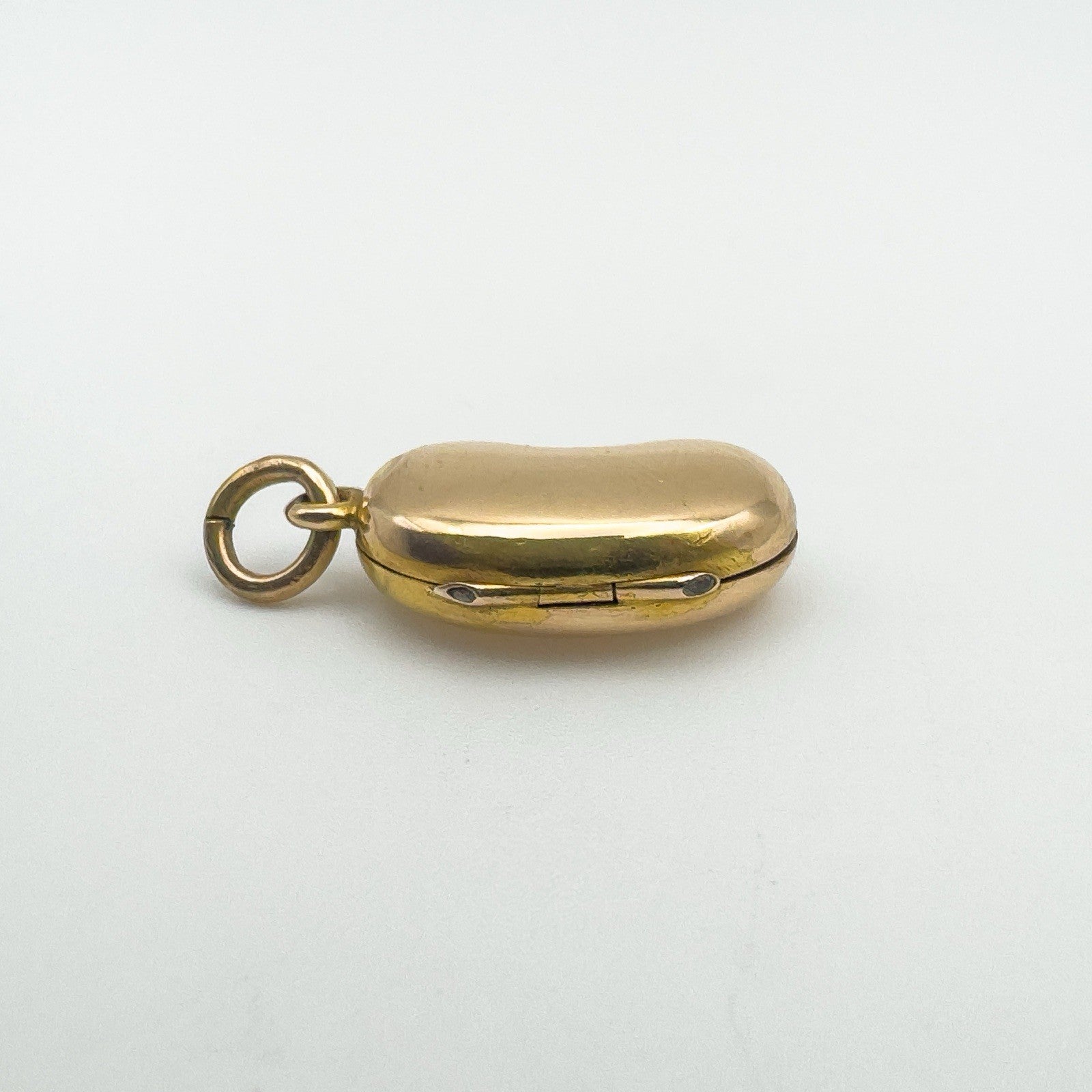 Close-up of side hinge and clasp on solid 18ct gold kidney bean locket pendant