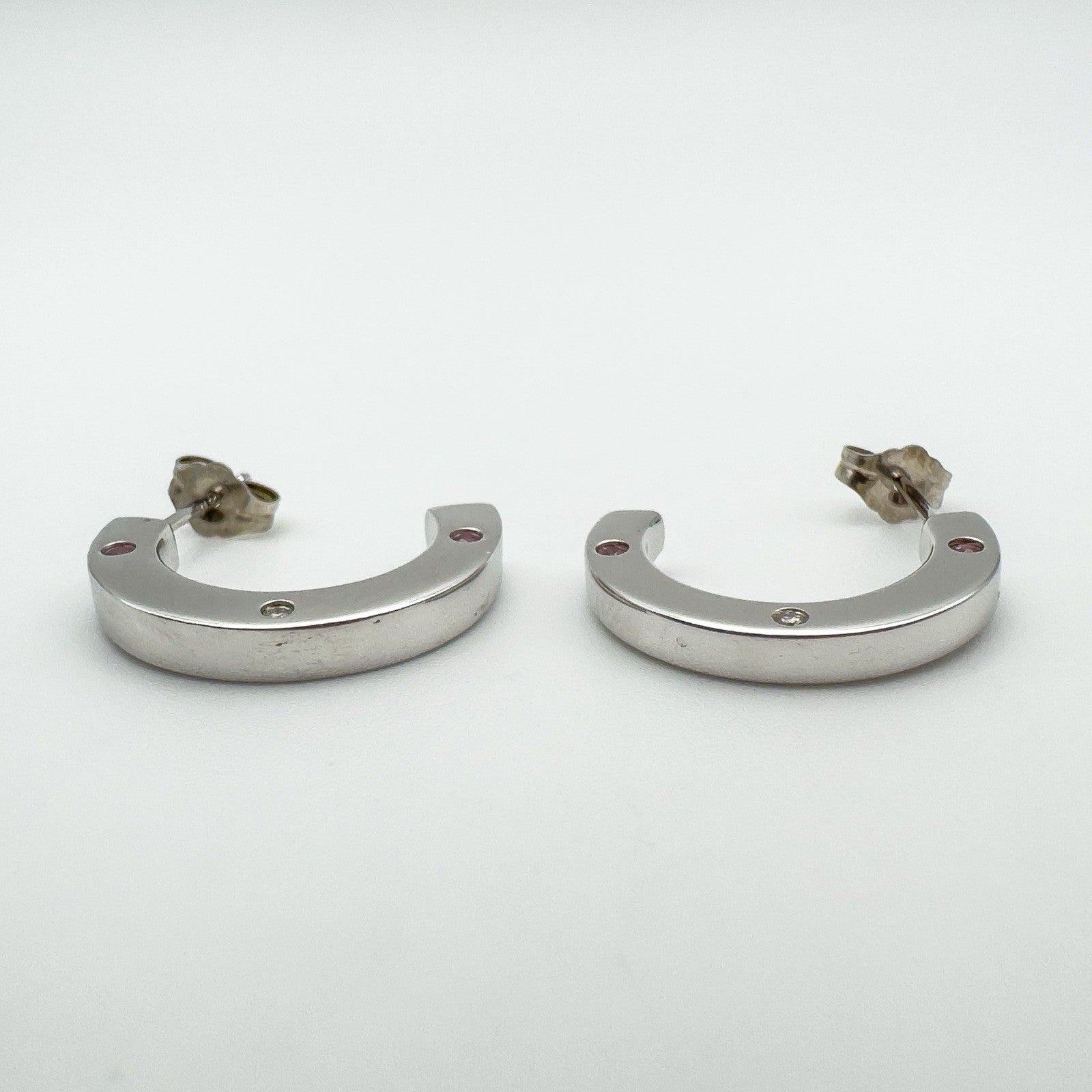 Earrings displayed horizontally to highlight depth and flat outer edge with gemstone accents