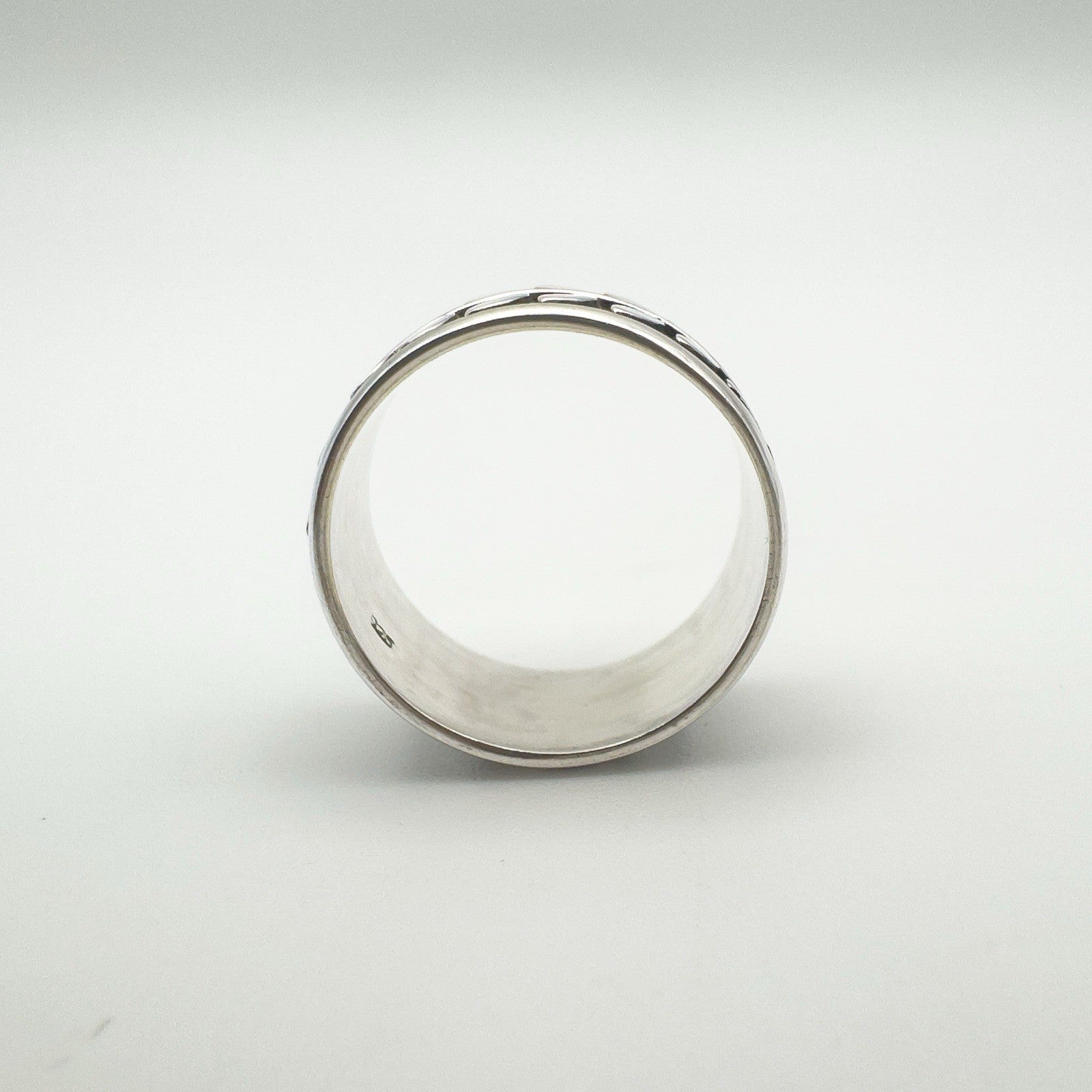 Interior of wide sterling silver ring showing curved band and hallmark
